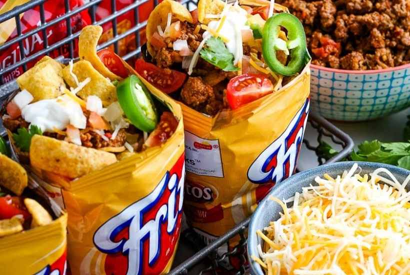 Close up of walking taco bar next to bowl of cheese.