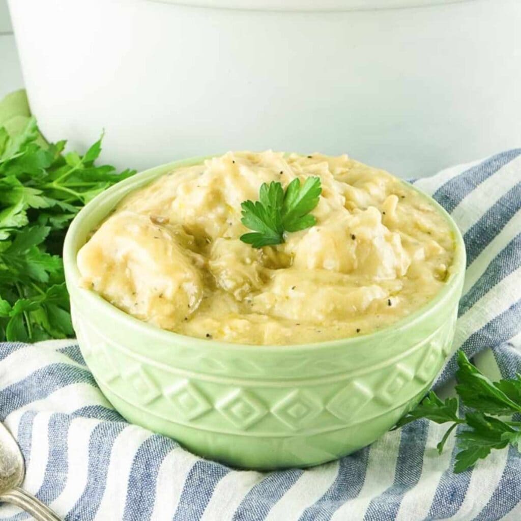 a soup bowl filled with slow cooker chicken and dumplings made from biscuits