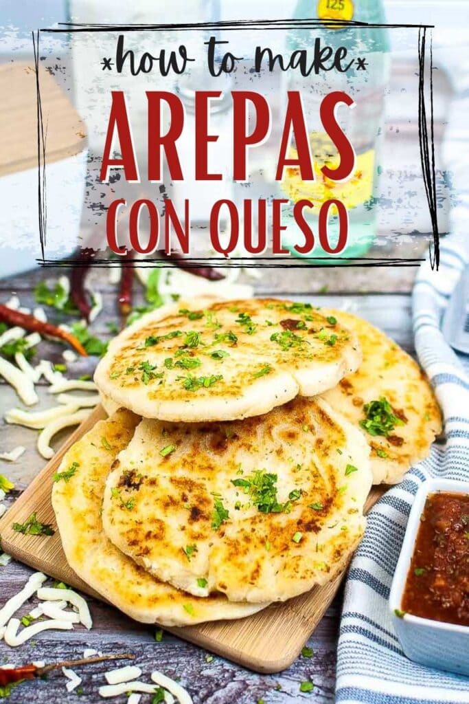 several Arepas Con Queso patties stacked on a wood cutting board with text overlay