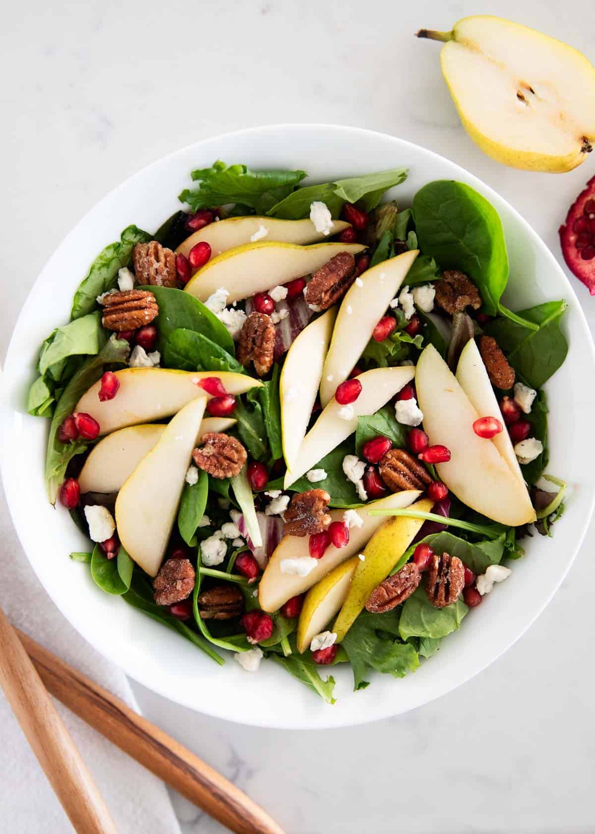 A salad made with pears, nuts and greens.