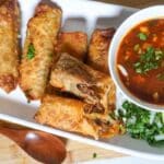 a platter of egg rolls filled with Mexican birria meat.