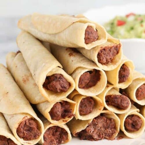 A plate of taquitos made of black bean filling.