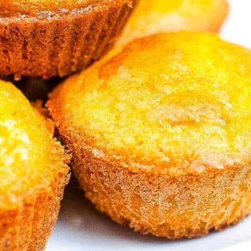 a stack of golden brown cornbread muffins.