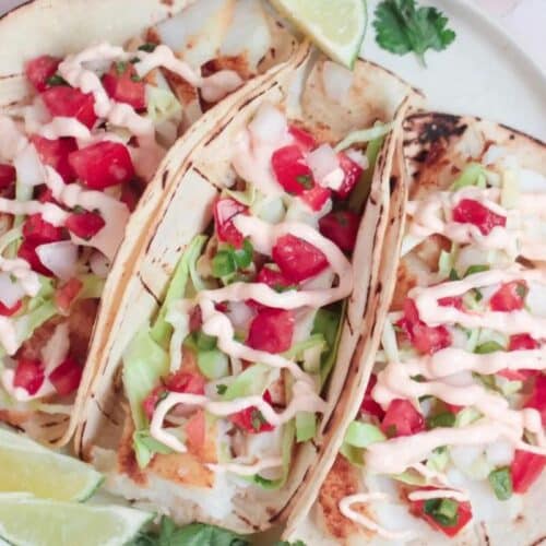 Three soft tacos with slaw and white fish filling.