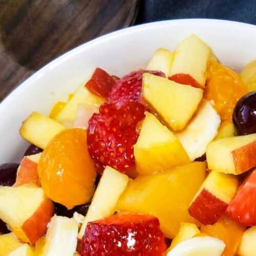 a bowl of fruit salad made with fruit cocktail and strawberries.