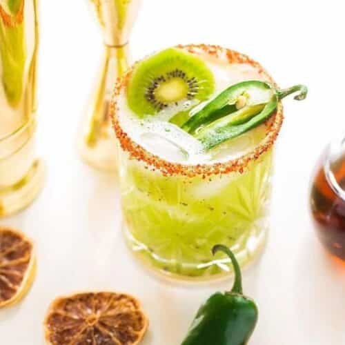 A kiwi margarita with jalapeno slices on the rocks.