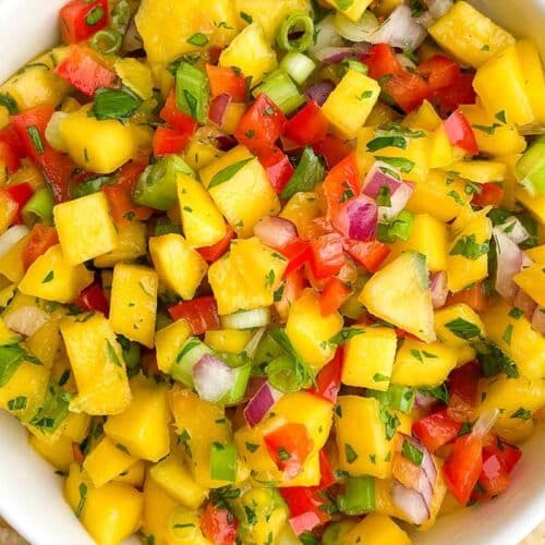 a bowl of salsa made with mango and peppers.