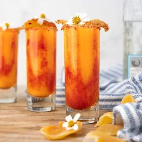 Three mango and tequila drinks with chamoy rim.