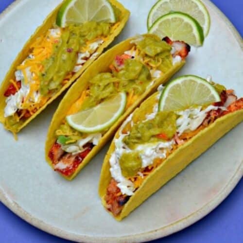 Three bbq pork chop tacos with guacamole.