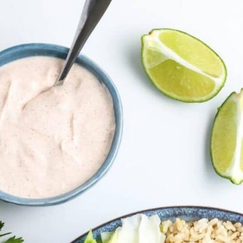 A bowl of homemade dressing with limes near.