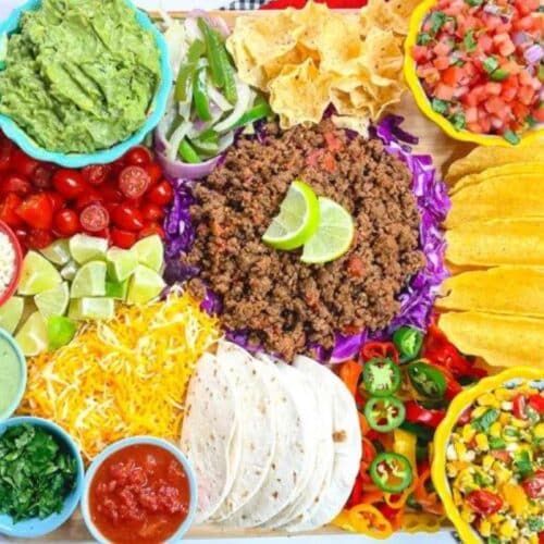 A spread of taco fillings with meat, cheese, and veggies.