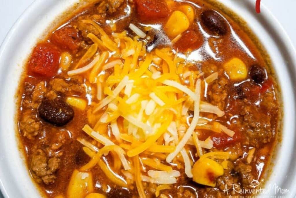 Overhead view of a bowl of taco soup with shredded cheese on top.