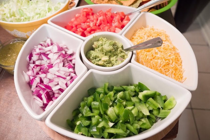 Divided serving tray filled with taco toppings.