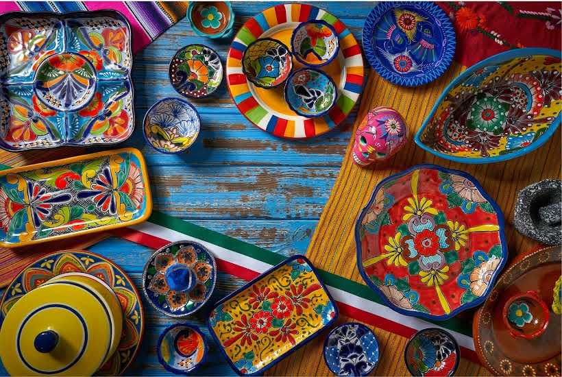 Festive colored serving dishes on a blue table.