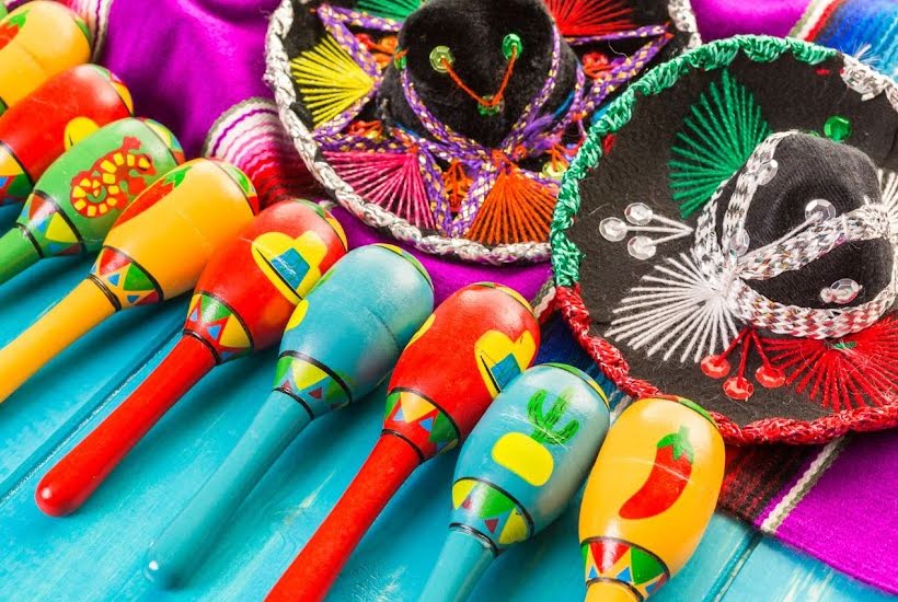 Colorful maracas and sombreros on a blue tabletop.