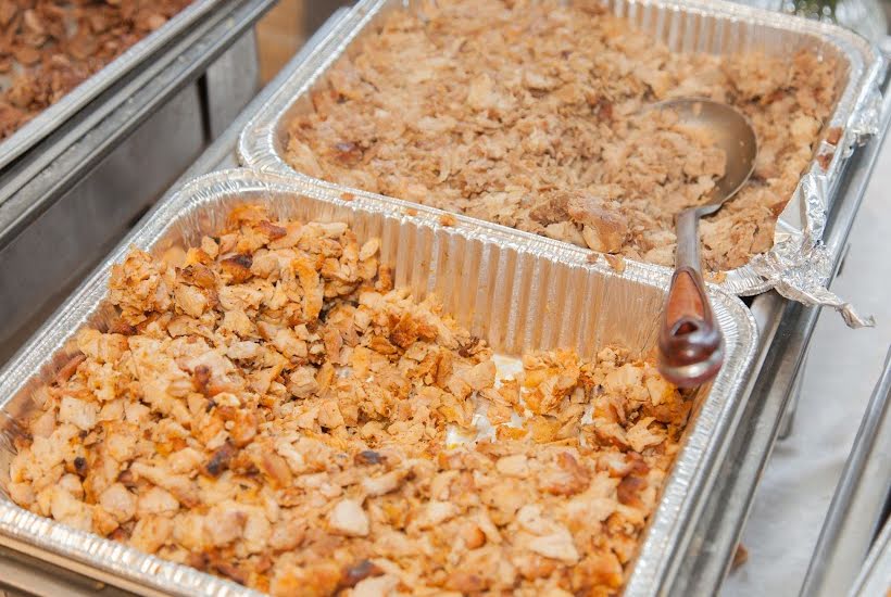 Silver pans filled with cooked taco meats.