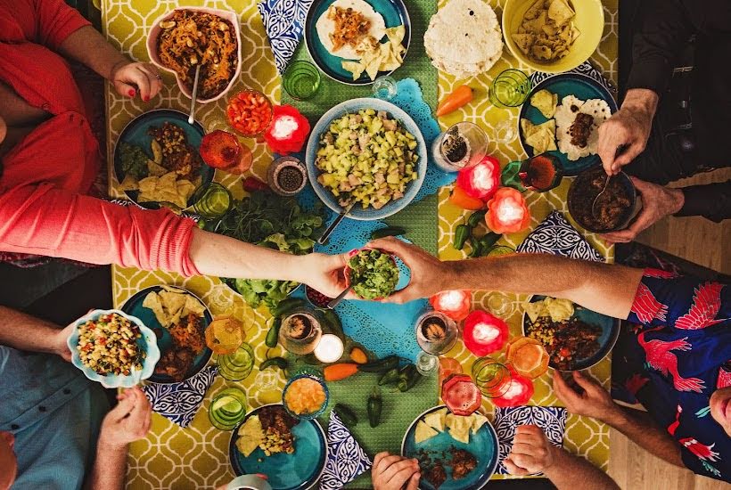 Top view of people eating taco party foods at a table.