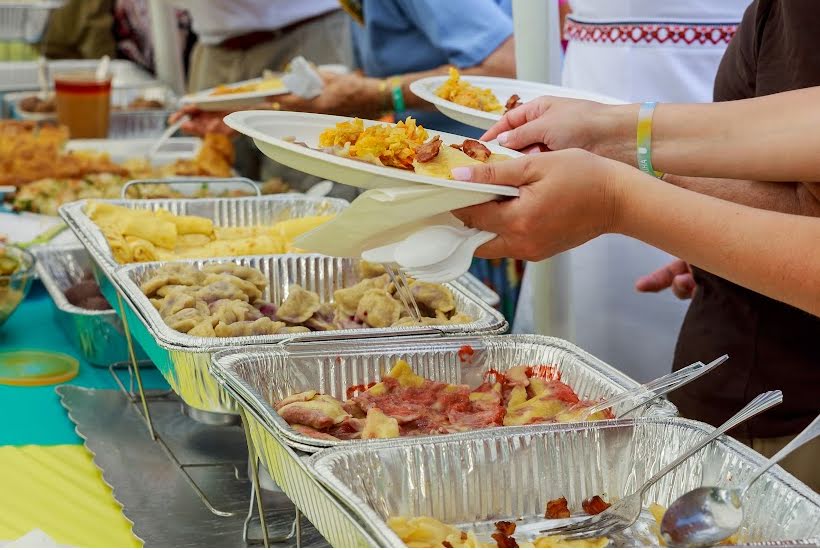 Foil chafing dishes filled with taco fillings and side dishes.