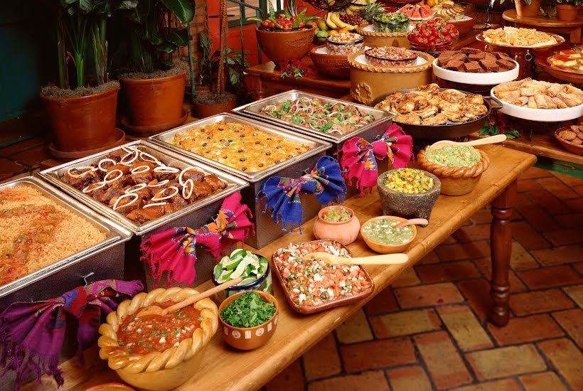 Buffet table filled with taco party foods.