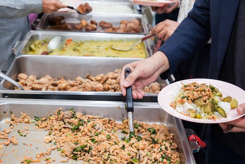 Chafing dishes filled with taco fillings and toppings.